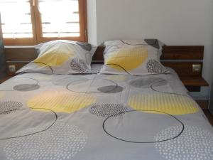 ベーブレンハイムにあるGîte Pinotのベッド(黄色と灰色のシーツ、枕付)