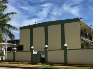 a white and green building with a fence at Beautiful 2 bedroom 1 bath in Tamuning