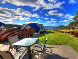 a patio area with a table and chairs at Beach Cabins Merimbula in Merimbula
