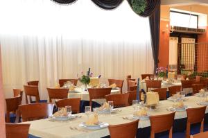 a conference room with tables and chairs and a large window at Hotel Rosamarina in San Giovanni Rotondo