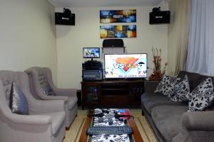 uma sala de estar com dois sofás e uma televisão em Villa Forest Hill B6 em Bandung