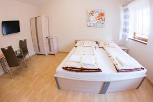 ein Schlafzimmer mit einem großen weißen Bett in einem Zimmer in der Unterkunft Guest House Tri Koruny in Spišská Stará Ves