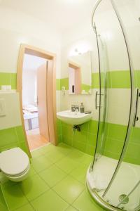 a green bathroom with a toilet and a sink at Guest House Tri Koruny in Spišská Stará Ves