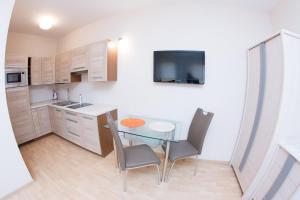 a small kitchen with a glass table and chairs at Guest House Tri Koruny in Spišská Stará Ves