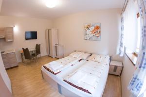 a bedroom with a bed and a table and a television at Guest House Tri Koruny in Spišská Stará Ves
