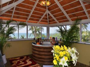 two women in a hot tub in a room with flowers at Orabella Villas & Suites in Calangute