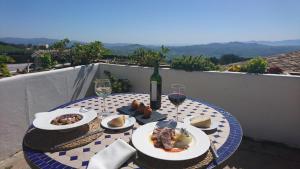 安特克拉Hotel Fuente del Sol的餐桌,带食物盘和一瓶葡萄酒