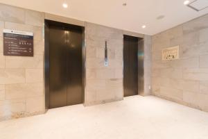 a hallway with two elevators in a building at Hotel Mystays Gotanda Station in Tokyo