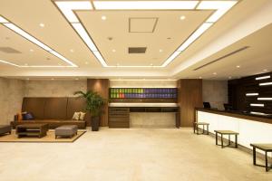 un vestíbulo de oficina con sofá y mesa en Hotel Mystays Gotanda Station en Tokio