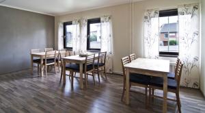 a dining room with tables and chairs and windows at Hotel & Hostel 10 in Gothenburg