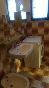 a bathroom with a sink and a toilet and window at Holiday Pool House in Pula