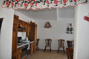 a kitchen with a counter and chairs in a room at Pensiune Muzeu Traditional Poveste in Transilvania in Sighişoara