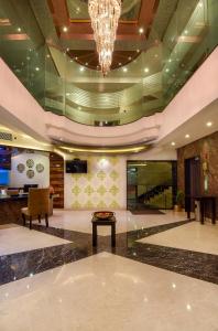 a lobby with a chandelier and a table at Akshaya Aura in Bengaluru