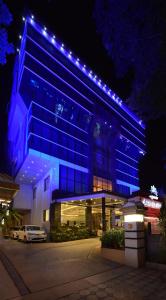 a blue building with a car parked in front of it at Akshaya Aura in Bengaluru