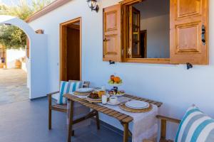 a table and chairs with food on it on a patio at Lindos SeaView Apartment in Líndos
