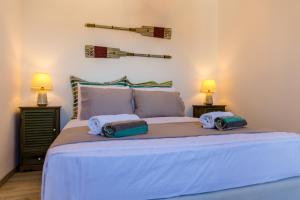 a bedroom with a large bed with two lamps at Lindos SeaView Apartment in Líndos