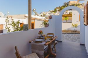 a table and chairs on the balcony of a house at Lindos SeaStar Apartment in Lindos