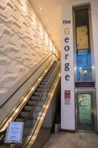 an escalator in a building with a sign that reads the elevator at George Limerick Hotel in Limerick