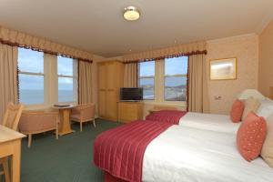 a hotel room with a bed and a desk at Imperial Hotel in Llandudno