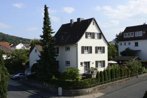 ein weißes Haus mit schwarzem Dach in der Unterkunft Ferienwohnung Barbara in Eschwege