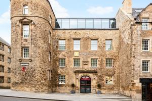 um grande edifício de tijolos com uma porta vermelha em Aparthotel Adagio Edinburgh Royal Mile em Edimburgo