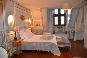 a bedroom with a bed with white sheets and pillows at La Tour du Lion in Rochefort-en-Terre +22 photos