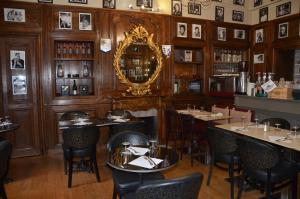 a restaurant with tables and chairs and a mirror at La Tour du Lion in Rochefort-en-Terre