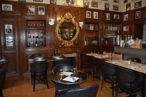 un ristorante con tavoli, sedie e specchio di La Tour du Lion a Rochefort-en-Terre