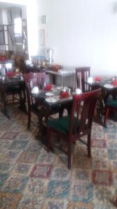 a dining room with wooden tables and chairs with red seats at The Glendale in Skegness +19 photos