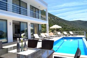 a villa with a swimming pool with chairs and avisor at My Villa in Kalkan