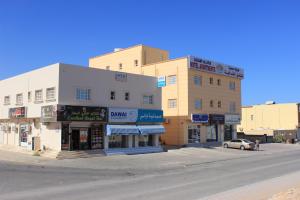 a building on the corner of a street at Luluat Al Afia Hotel Apartments in Sur