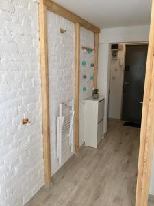 a room with a white brick wall and a kitchen at Apartament Żelazna in Warsaw