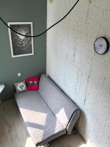 a couch in a room with a clock on the wall at Apartament Żelazna in Warsaw
