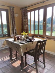 a dining room with a table and chairs and windows at Wood Farm Kerdiston in Reepham