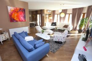 sala de estar con sofá azul y sillas en Farah Superior Apartments, en Bihać