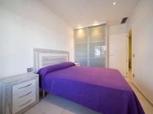 ロザスにあるInmoSantos Oasis E2のベッドルーム(紫色のベッド1台、キャビネット付)