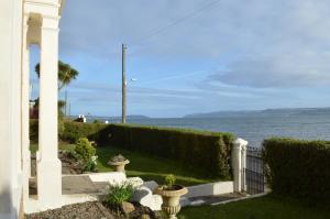 a house with a fence and a view of the water at Briar Brae Bed & Breakfast in Stranraer