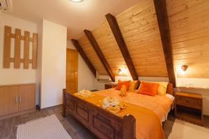 una camera da letto con un grande letto con cuscini arancioni di Guest House Rustico a Korenica