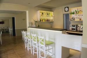 a bar with a row of white stools at Hotel Merkur in Miercurea-Ciuc