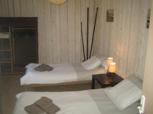Zimmer mit 2 Betten und einem Tisch mit einer Lampe in der Unterkunft les théolats in Rochefort-en-Valdaine