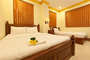 a bedroom with a bed with a flower on it at Golden House International Hotel in Phnom Penh