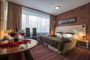 una camera d'albergo con due letti e un tavolo con bicchieri da vino di Hotel Delta a Cracovia