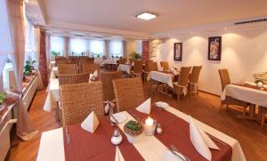 a restaurant with tables and chairs in a room at Hotel Flurschütz in Lennestadt
