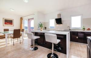 a kitchen and dining room with a table and chairs at Apartments Host in Rab