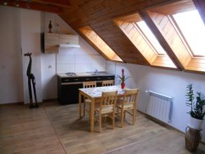 a kitchen with a table and chairs and skylights at Apartament Kurzejówka in Rabka-Zdrój