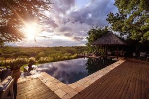 a pool with a gazebo next to a wooden deck at Khaya Ndlovu Safari Manor in Hoedspruit