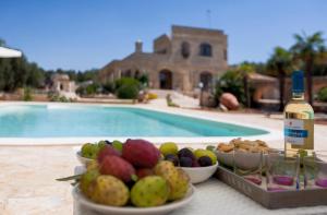 een tafel met fruitschalen en een fles wijn bij Casale Tre Petre by BarbarHouse in Santa Maria al Bagno