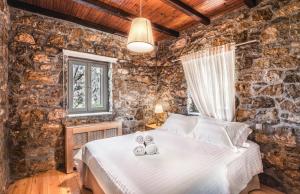a bedroom with a bed in a stone wall at Avrofilito Syros Houses in Ermoupoli +107 photos