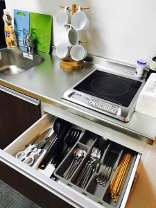 an open drawer in a kitchen with a tablet in it at Sun Heights Ikebukuro in Tokyo