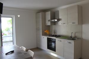 a kitchen with white cabinets and a table and a stove at Appartamenti Muccioli Misano in Misano Adriatico